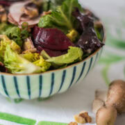 seitliche Ansicht von gestreifter Schüssel gefüllt mit grünem Salat, roter Bete und Champignons