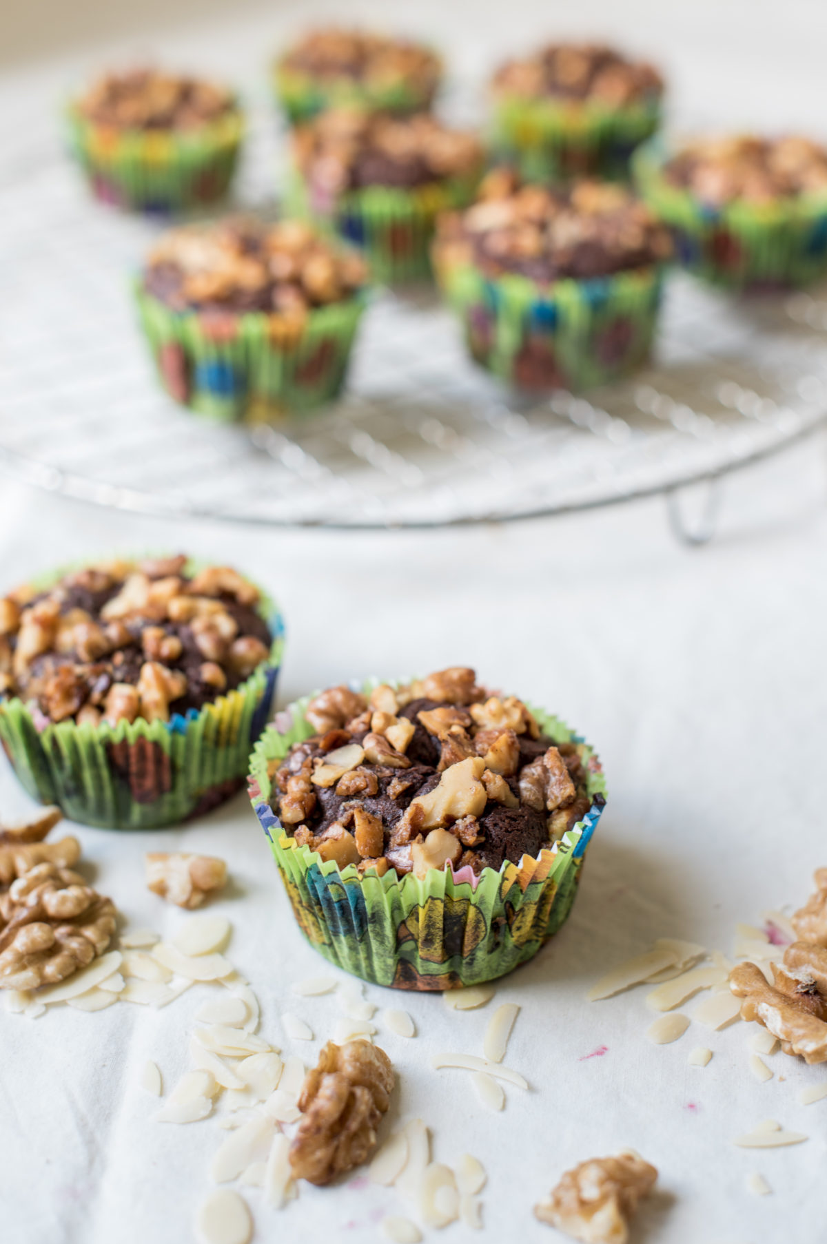 leicht erhöhte Ansicht von zwei Schokomuffins vor Backrost mit weiteren Muffins