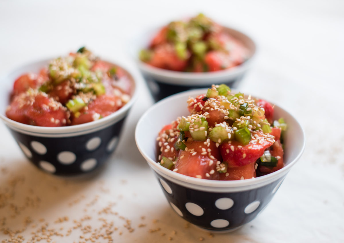 Drei gepunktete Schüsseln gefüllt mit Wassermelonen Salat und mit Sesam und Kräutern garniert