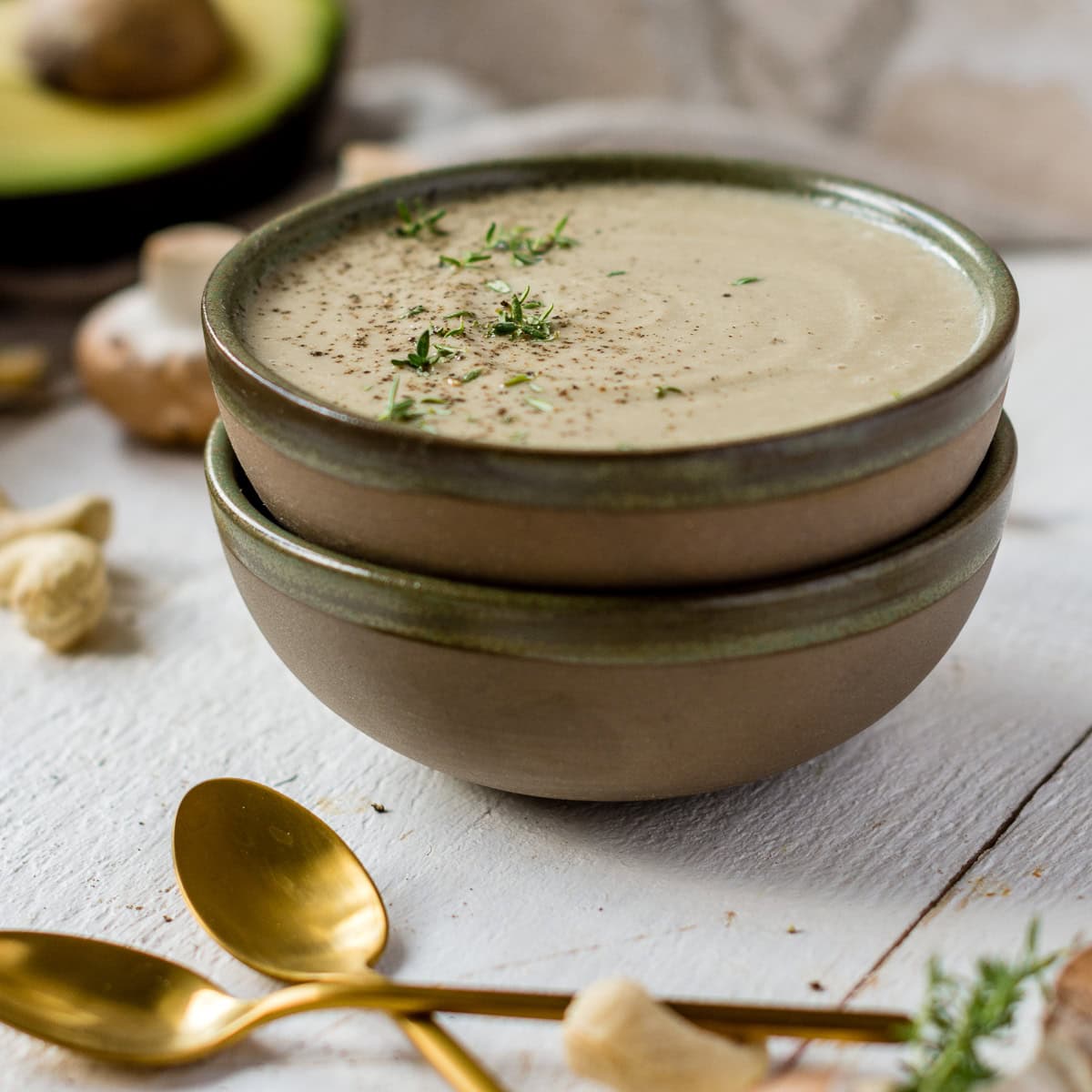 Schüssel mit Suppe gefüllt auf weißem Holzuntergrund