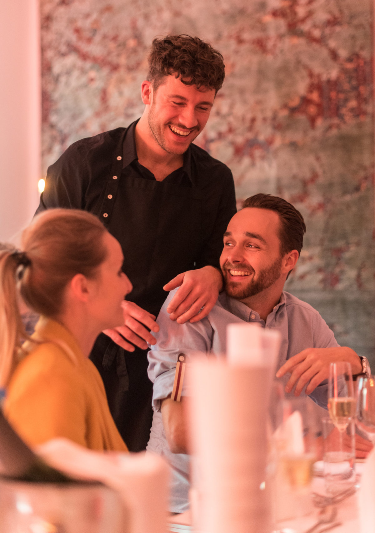 Personen in einem Restaurant lachen und amüsieren sich.