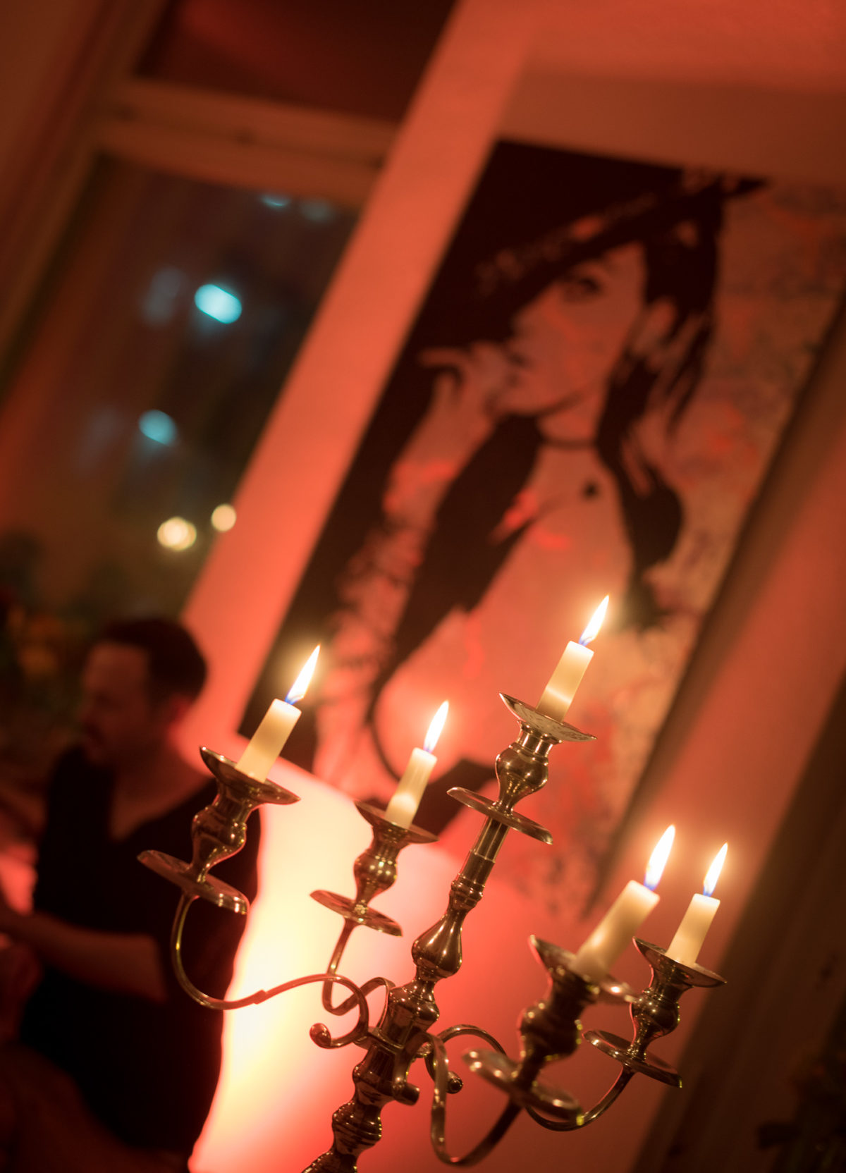 Kerzenständer vor Gemälde bei gedimmten Licht.