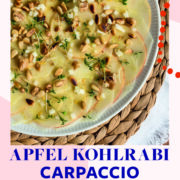 Topshot von weißem Teller mit Kohlrabi -Apfel-Carpaccio, getoppt mit Pinienkernen und Kresse