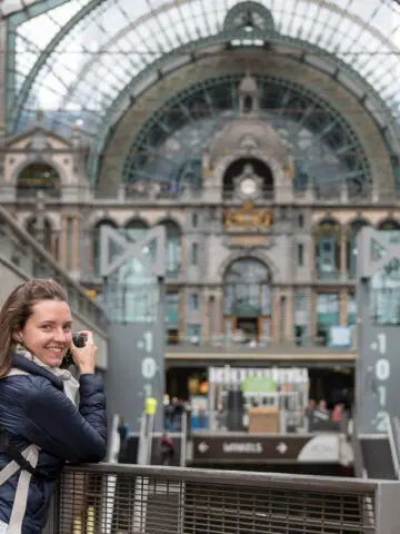 Bahnhof Antwerpen mit Frau, die über Schulter schaut