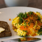 Rührei mit Fischrogen und Dill auf Teller mit Brot