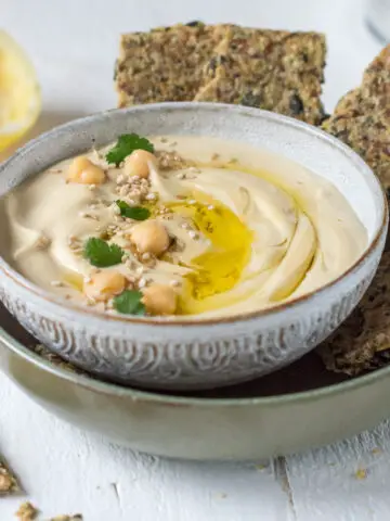 Hummus in Schale mit Kichererbsen und Knäckebrot