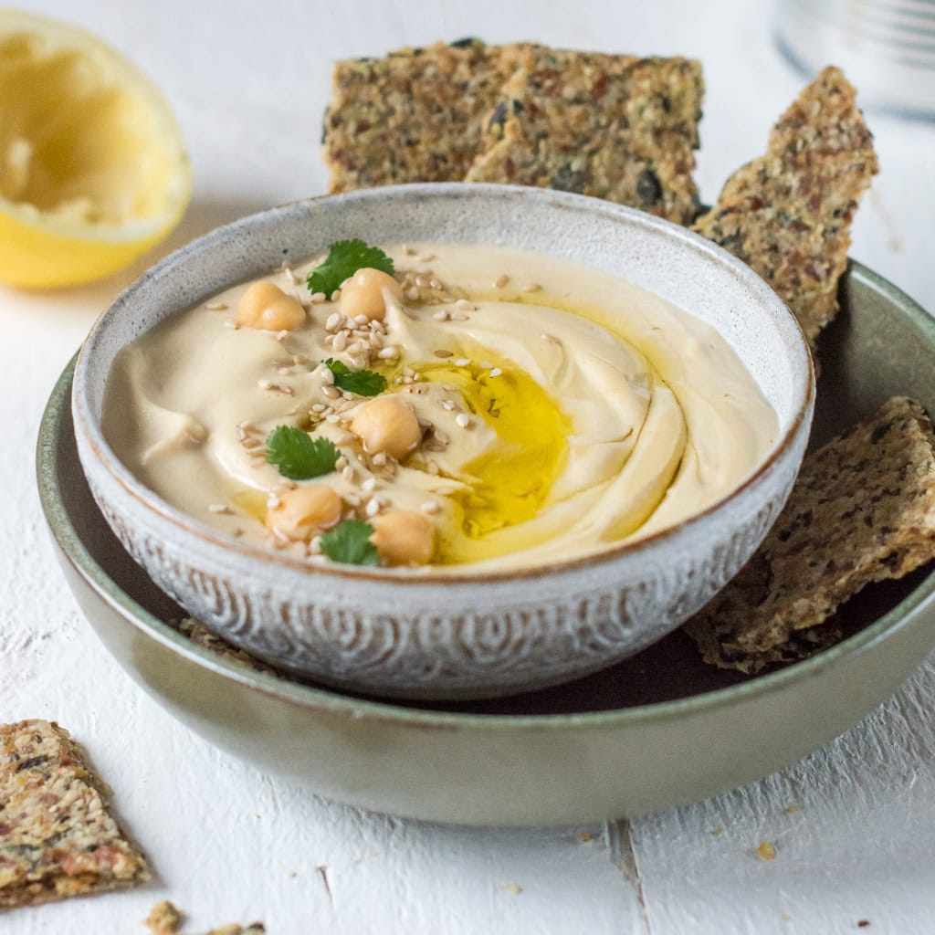 Hummus in Schale mit Kichererbsen und Knäckebrot