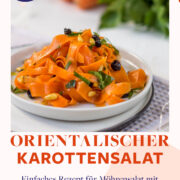 Karottensalat mit Rosinen und Curry auf weißen Teller angerichtet