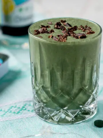 grüner Smoothie im Glas mit Kakaonibs bestreut