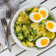 Topshot von Kartoffelsalat mit vier Eierhälften und Petersilie und zwei Gabeln