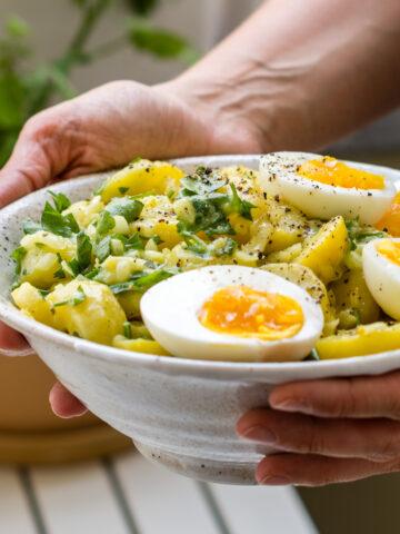 Kartoffelsalat mit Eierhälften und Petersilie in Schüssel