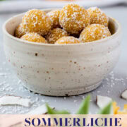 Schüssel gefüllt mit sommerlichen Energiebällchen und Kokosraspeln.