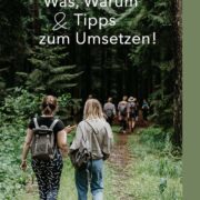 Rückansicht von zwei Frauen die auf einem Waldweg laufen.