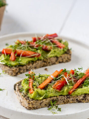 zwei Scheiben glutenfreies Körnerbrot mit Avocado und Paprika belegt