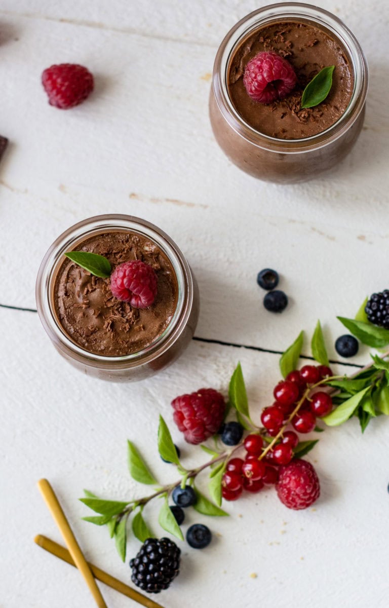 Mousse au Chocolat Schokoladendessert in zwei Gläsern und mit Beeren garniert.