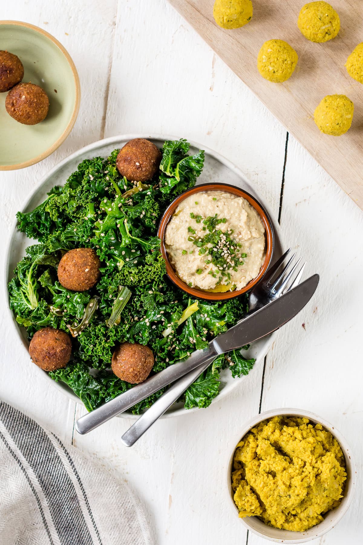 Pinne das Foto, um das Rezept schnelle Falafel mit Hummus und Grünkohl zu speichern! Topshot Curry-Falafeln mit gebratenem Grünkohl und Hummus, daneben Falafel Bällchen vor dem Backen