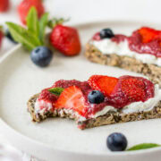 Heller Teller mit zwei Schreiben Brot die mit Frischkäse und Chiamarmelade bestrichen sind.