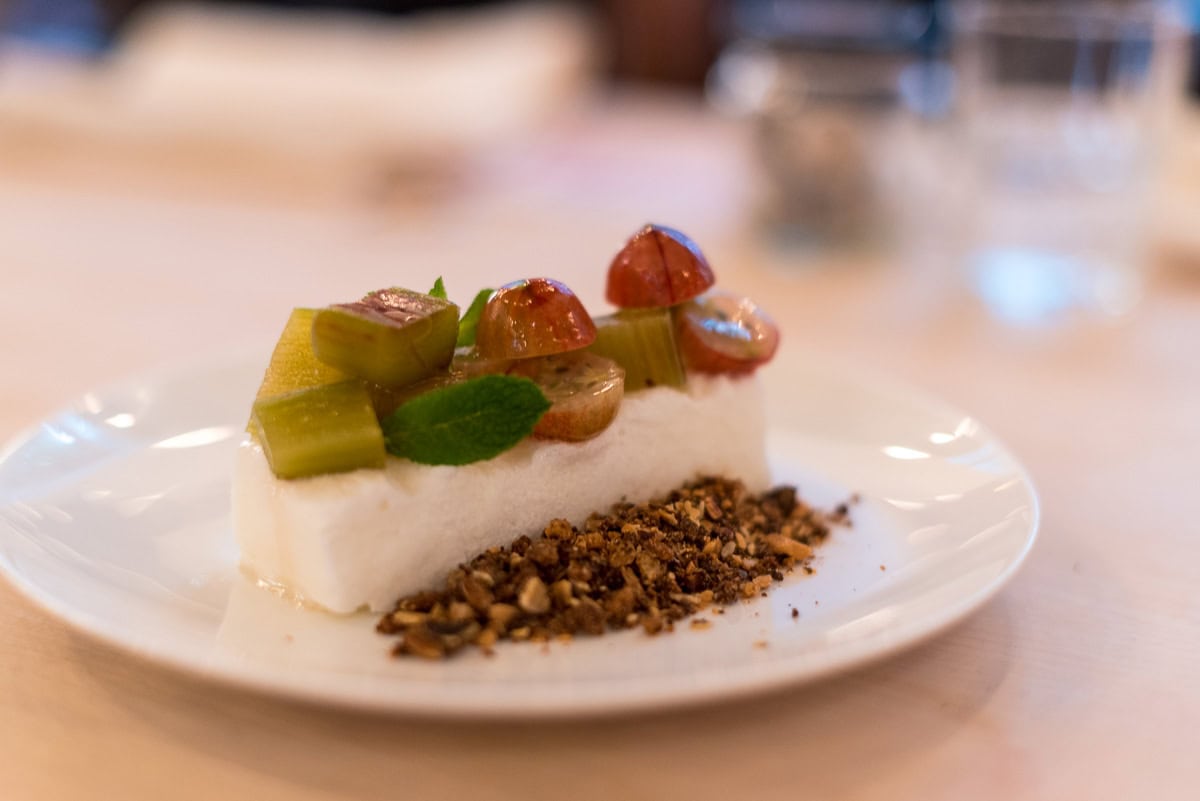 Ein Dessert mit Stachelbeeren und Rhabarber auf einem weißem Teller.