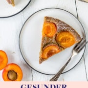 Zwei Stück Aprikosenkuchen auf weißen Tellern mit einer Gabel und frische Aprikosen.