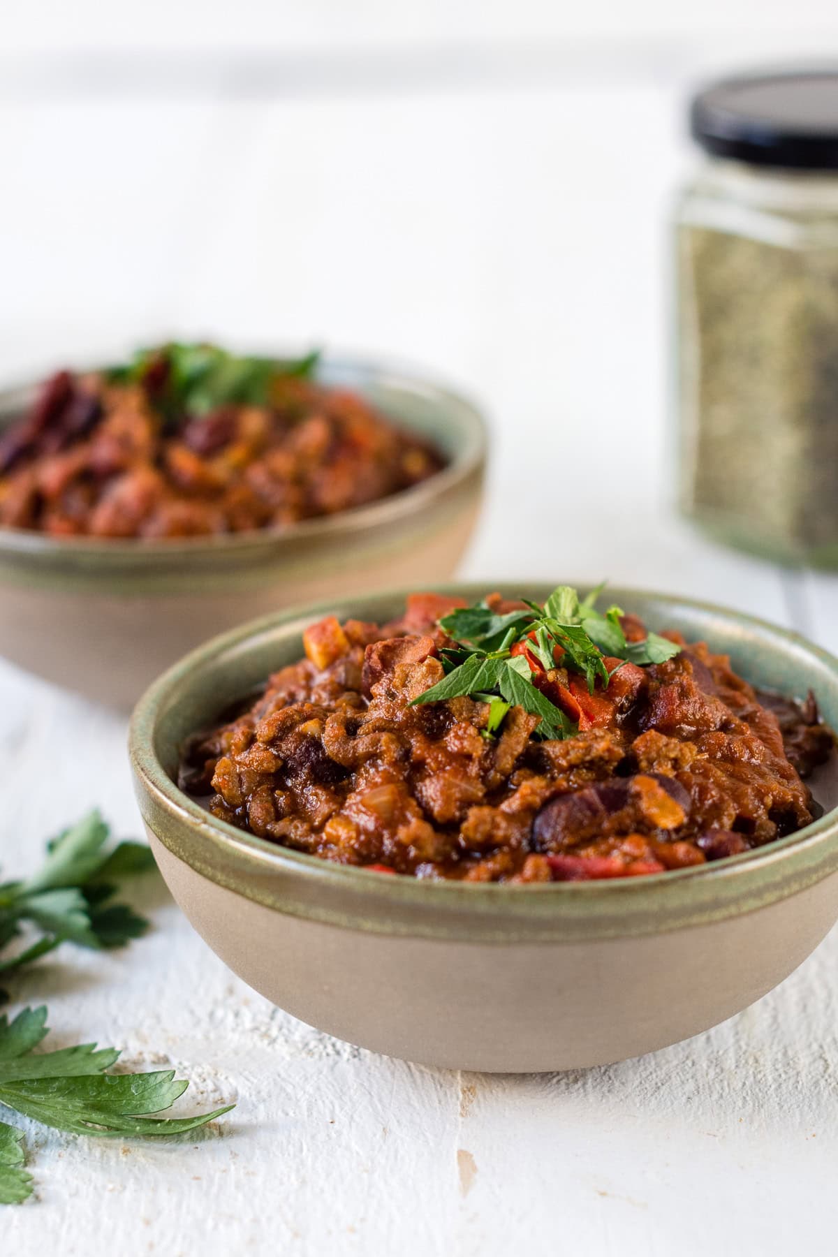 Zwei Schüsseln Chili von Carne mit Kräutern.