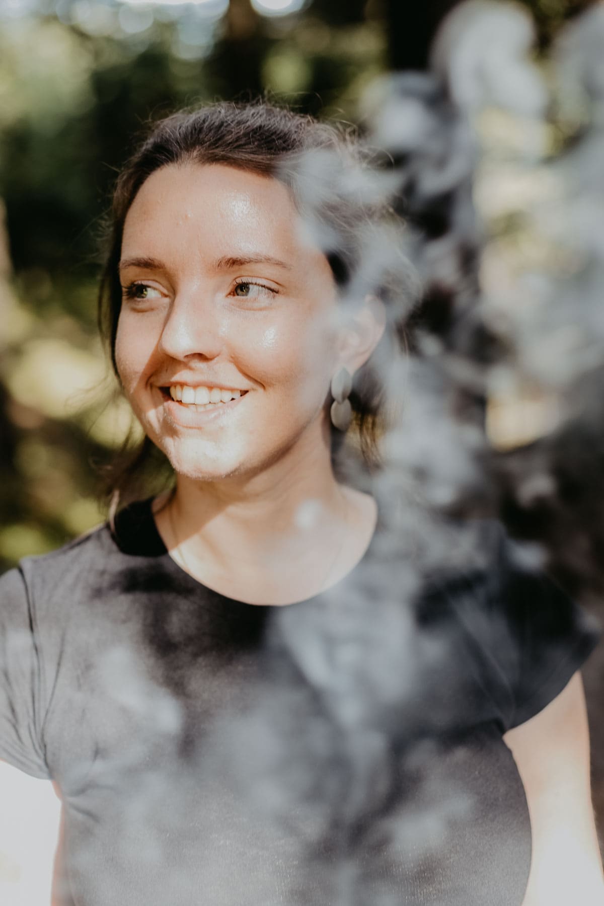 Pinne das Foto, um meinen Beitrag über Waldbaden zu speichern! Frau im Wald lächelt an der Kamera vorbei