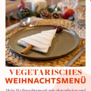Vegetarisches Weihnachtsmenü mit weihnachtlich dekoriertem Teller mit einem Tannenbaum aus Servietten und Zimt. Im Hintergrund Weihnachtsdekoration und Gläser.