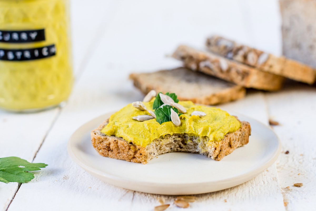 Pinne das Foto um dir das Rezept für veganen Curry Brotaufstrich zu speichern Brot mit gelbem Curry Aufstrich, Sonnenblumenkernen und Petersilie