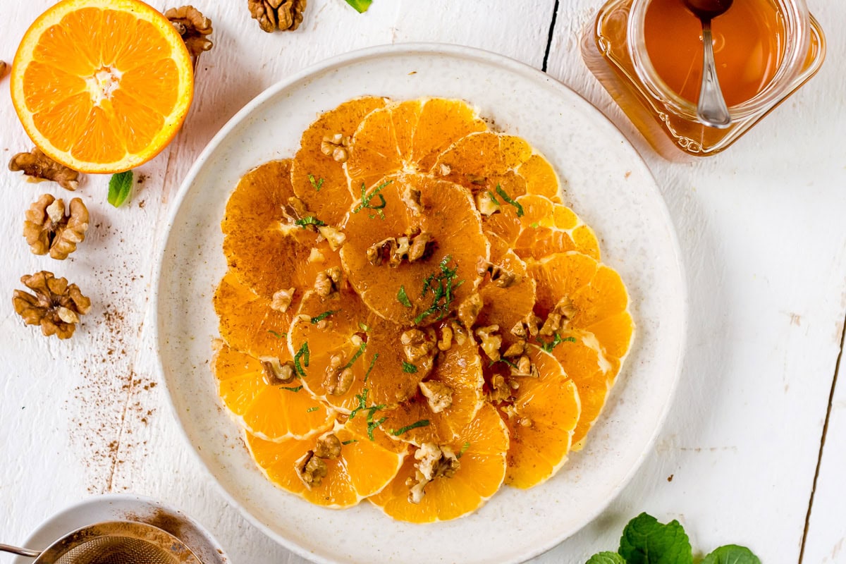 Pinne das Foto, um das Rezept für das Orangen Carpaccio zu speichern! Topshot des Orangen Carpaccios mit Zimt und Walnüssen.