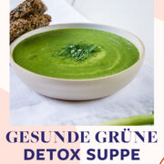 Teller mit grüner Detox Suppe und frischen Kräutern mit zwei Scheiben Brot.