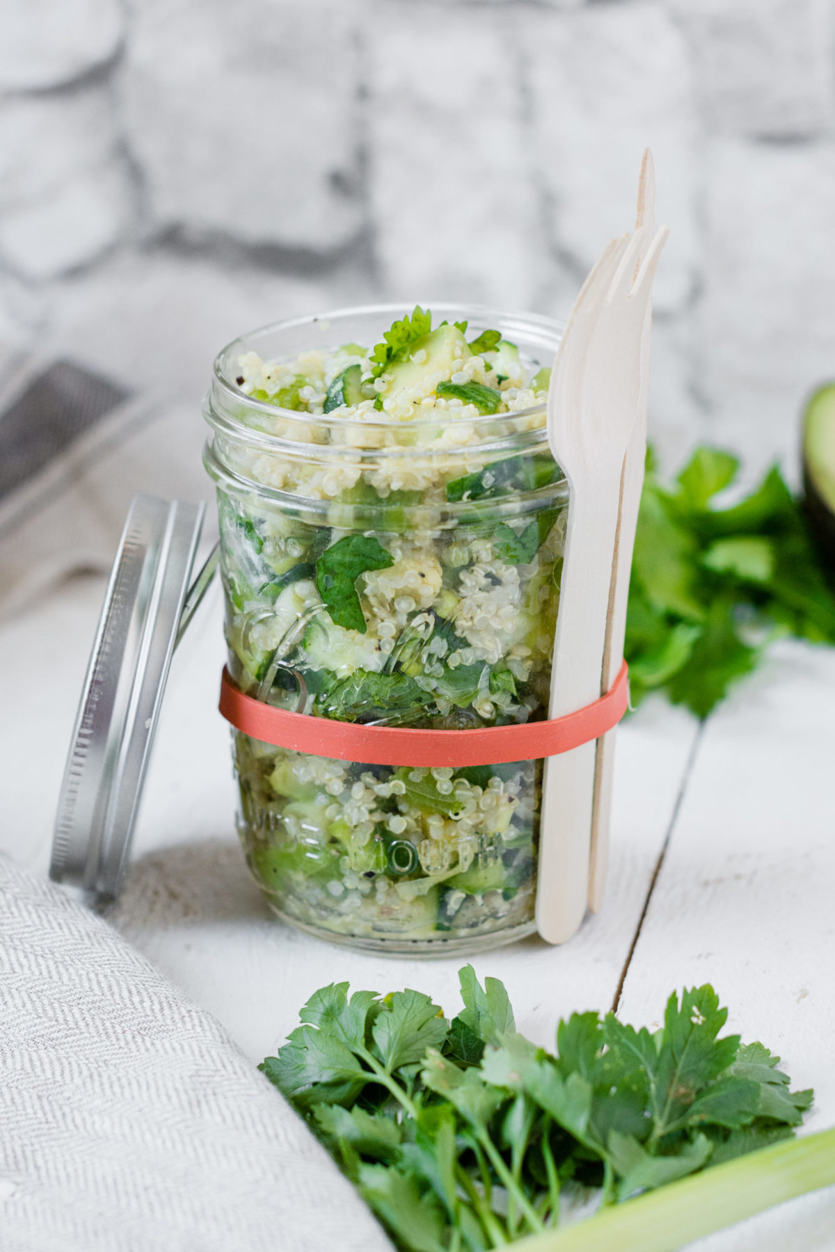 Front Shot von einem Einmachglas gefüllt mit veganem Quinoa-Gemüse Salat.