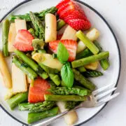 Nahaufnahme von Spargelsalat mit Erdbeeren, Lauchzwiebel und Basilikum