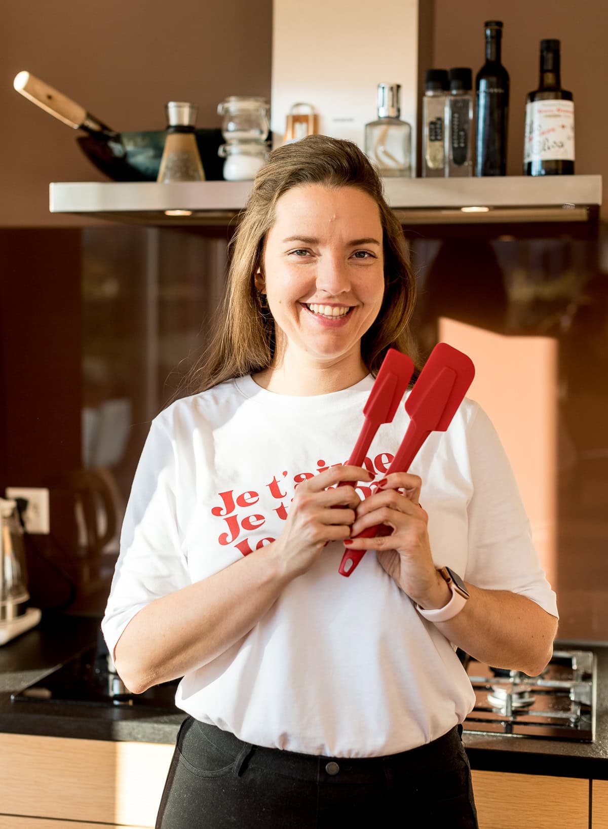 Frau hält zwei rote Küchenhelfer (Teigschaber) in der Hand.