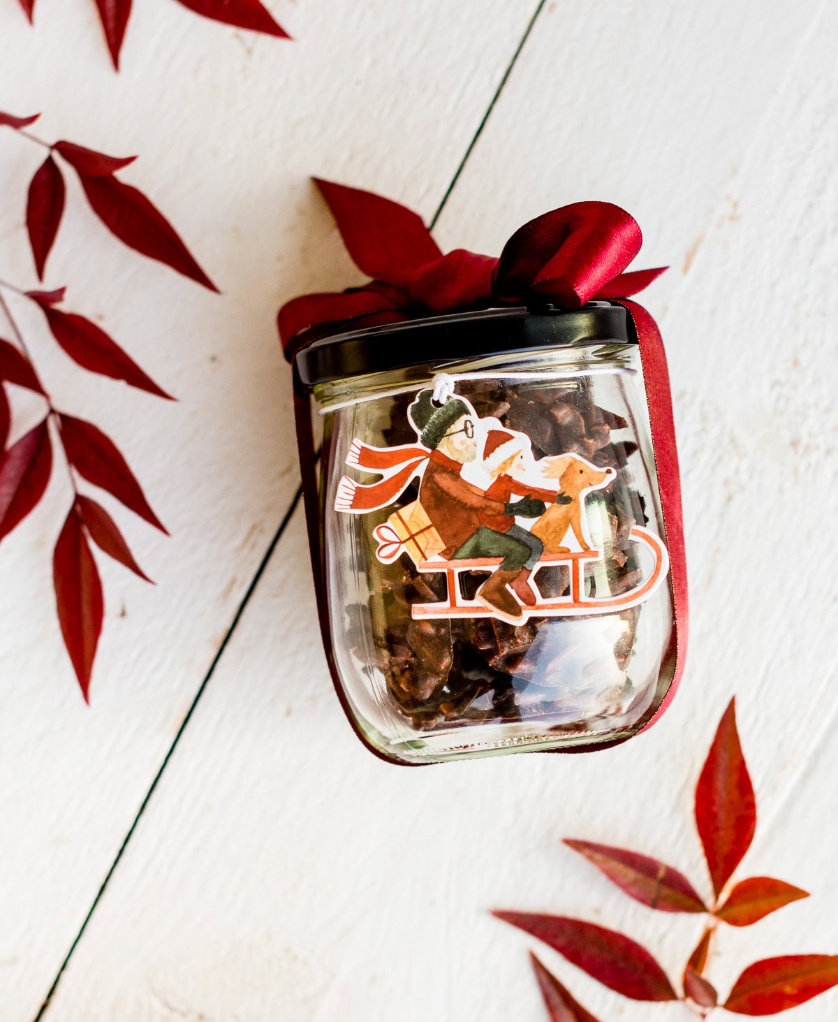Speichere dieses Foto, um das Rezept für Mandelsplitter zu sichern! Weihnachtlich dekoriertes Glas gefüllt mit Mandelsplittern auf weißem Untergrund.