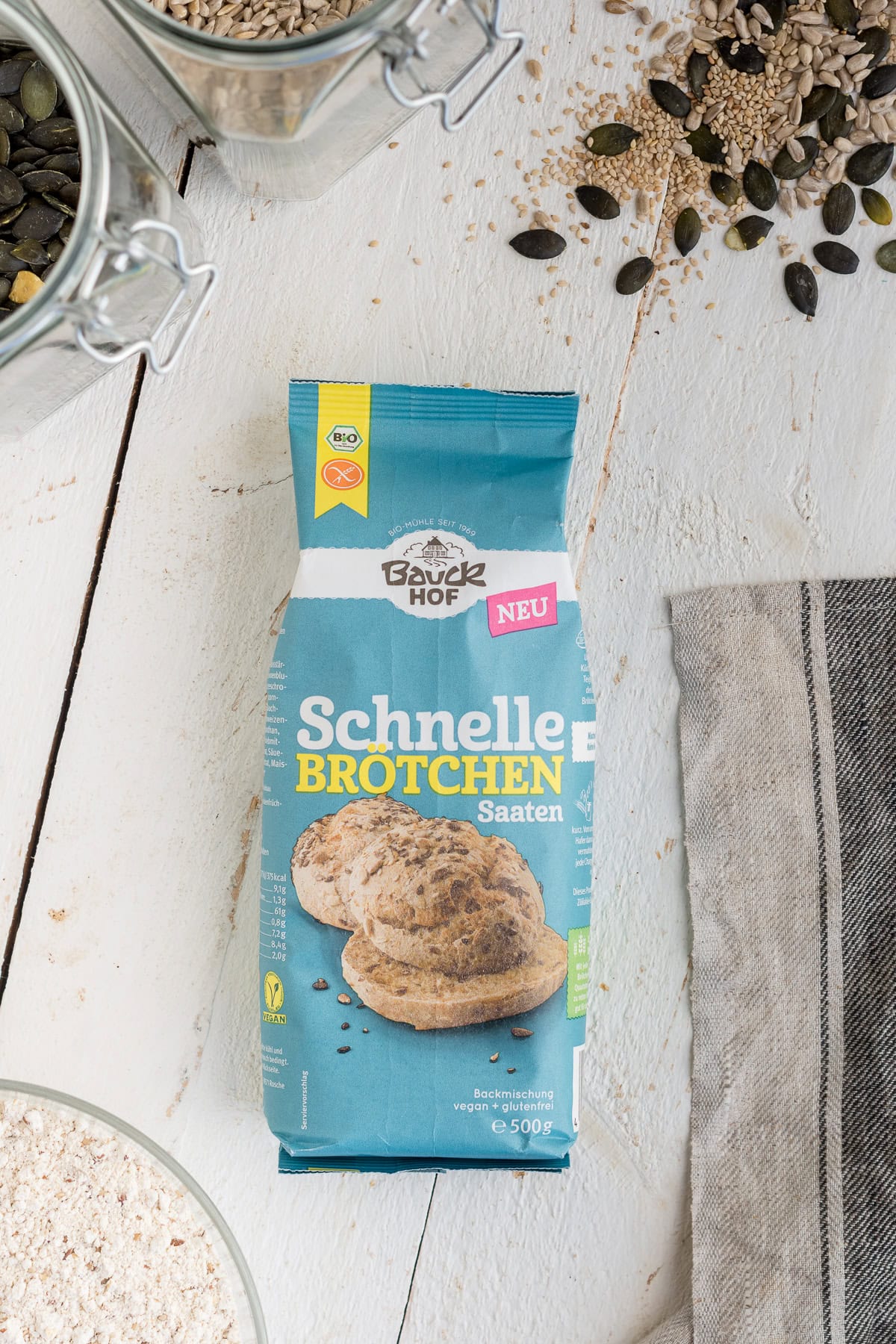 Speichere dieses Foto, um dir das Rezept für diese glutenfreien und veganen Brötchen zu sichern! Topshot von einer Bauckhof SchnelleBrötchen Backmischung auf weißem Untergrund.