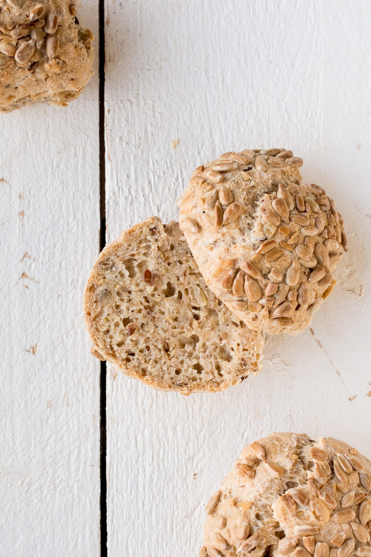 Speichere dieses Foto, um dir das Rezept für diese glutenfreien und veganen Brötchen zu sichern! Topshot von glutenfreien, veganen Brötchen auf weißem Untergrund.