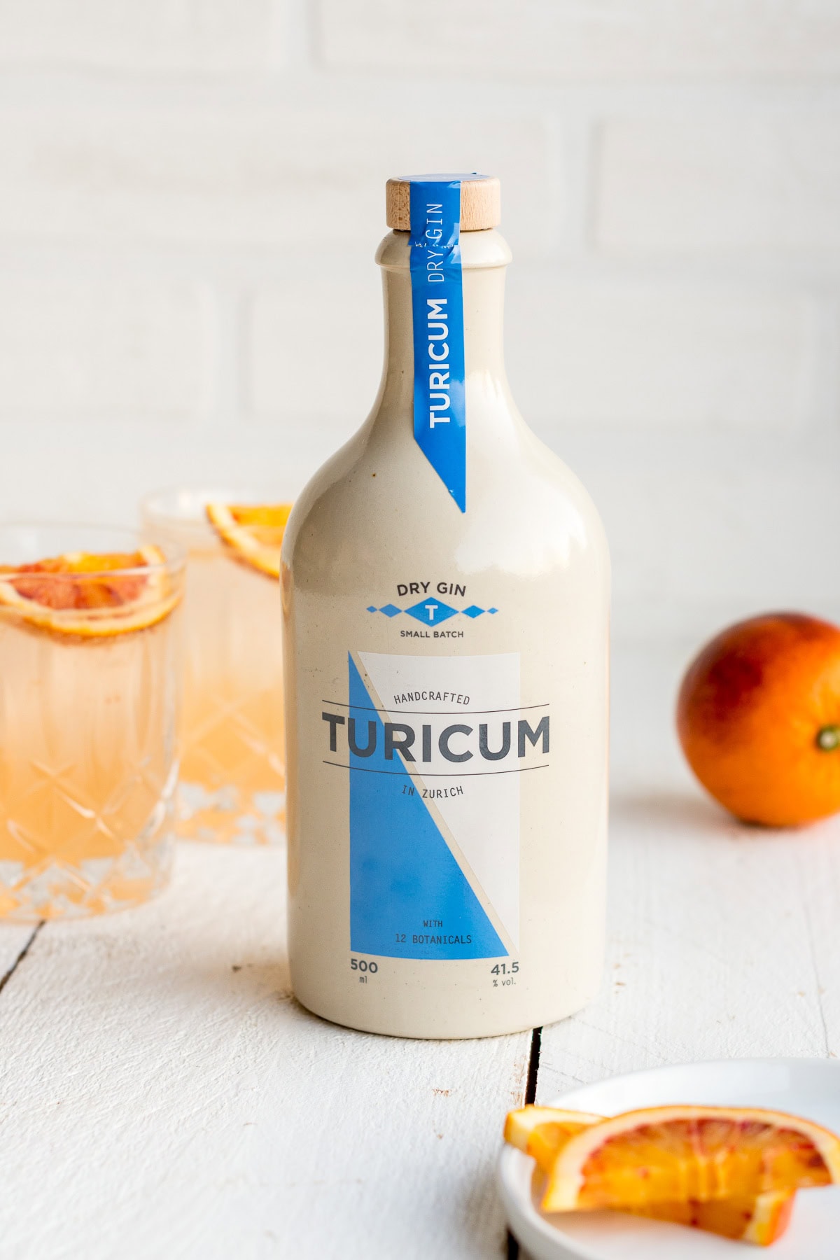 Pinne das Foto, um das Rezept für den sommerlichen Cocktail zu speichern! Front Shot von einer Flasche Turicum Dry Gin vor hellem Hintergrund.