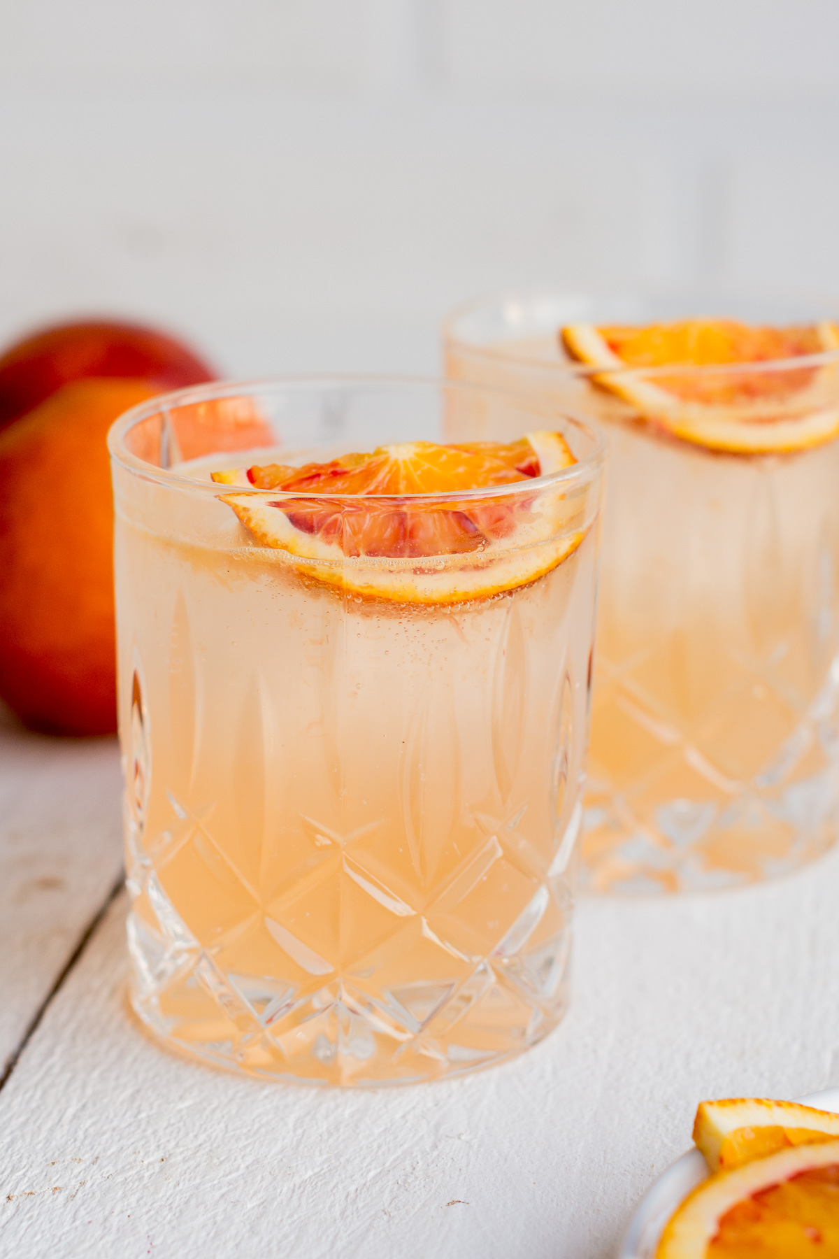Front Shot von einem sommerlichen Cocktail mit Ginger Ale, Orange und Gin in Whiskeygläsern.