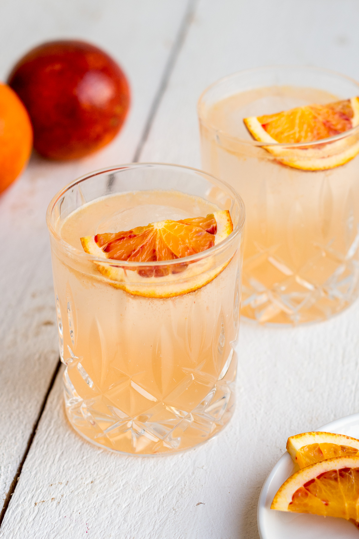 Front Shot von einem sommerlichen Cocktail mit Ginger Ale, Orange und Gin in Whiskeygläsern.