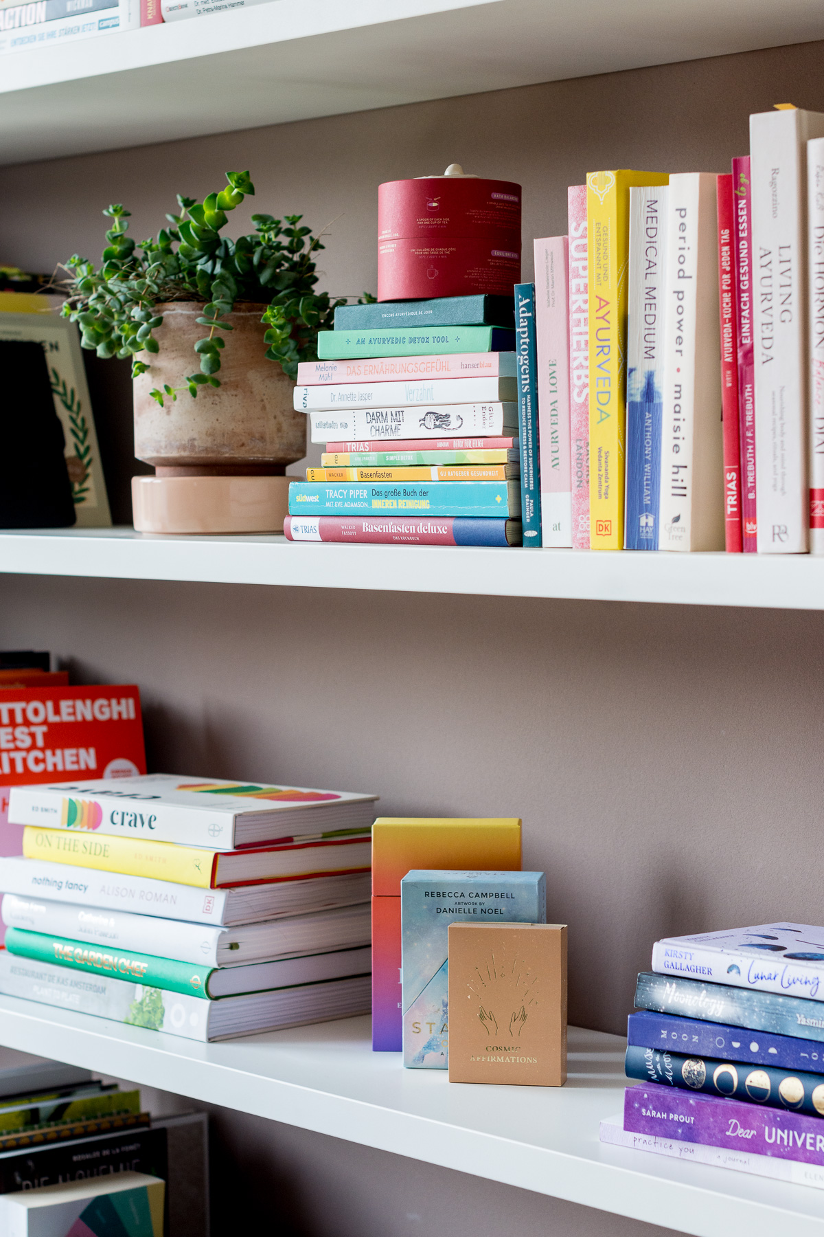 Foto von einem ästhetischen Bücherregal in dem verschiedene Bücher rund um das Thema Wellbeing stehen.