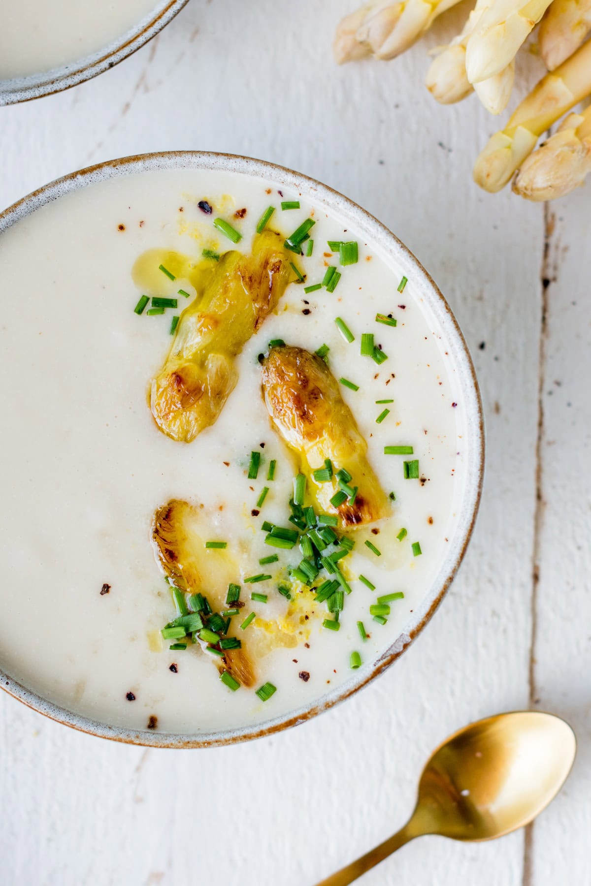 Topshot von einer Schale veganer Spargelcremesuppe.