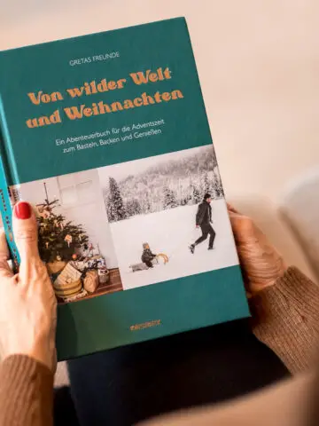 Frau mit Buch "Von wilder Welt und Weihnachten" in der Hand